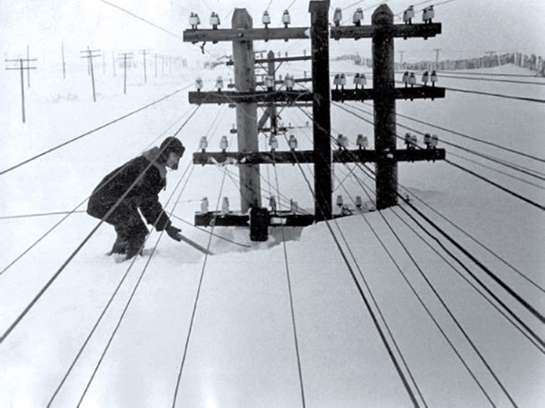 Суровая зима. Снегом замело деревянные опоры ЛЭП